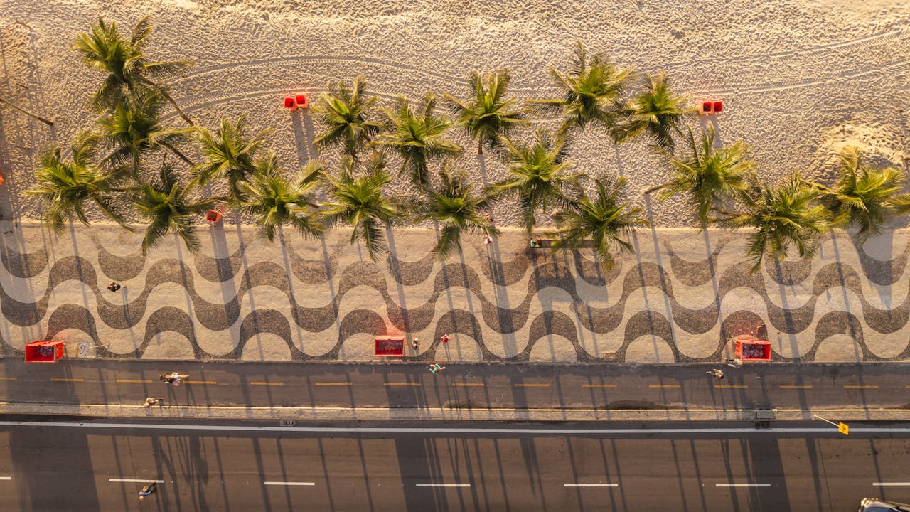 Aerial view of Copacabana Beach in Rio de Janeiro showcasing palm trees and iconic wavy pavements.